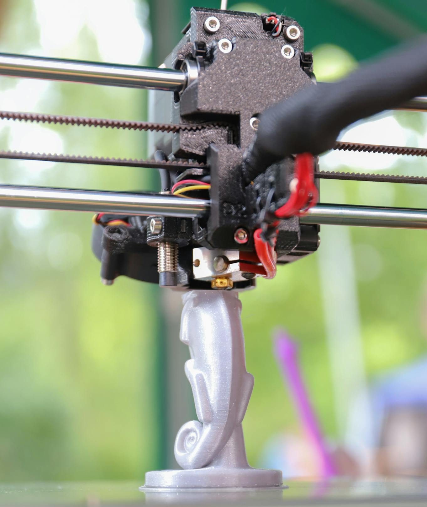 Close-up of a 3D printer creating a decorative figurine, showcasing modern technology in action.